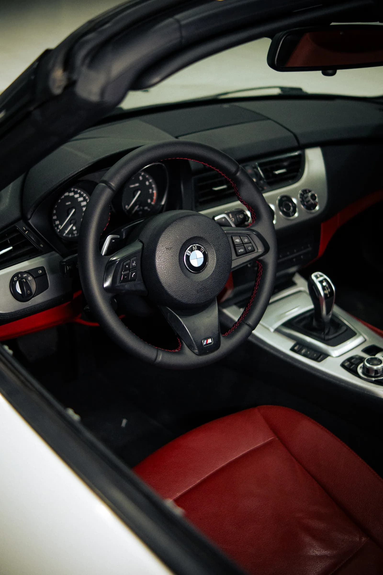 Interior de BMW com bancos vermelhos e volante com costura vermelha